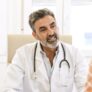 Happy male doctor talking to female patient in clinic