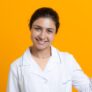 Portrait of indian doctor woman in white medical gown isolated on yellow background.